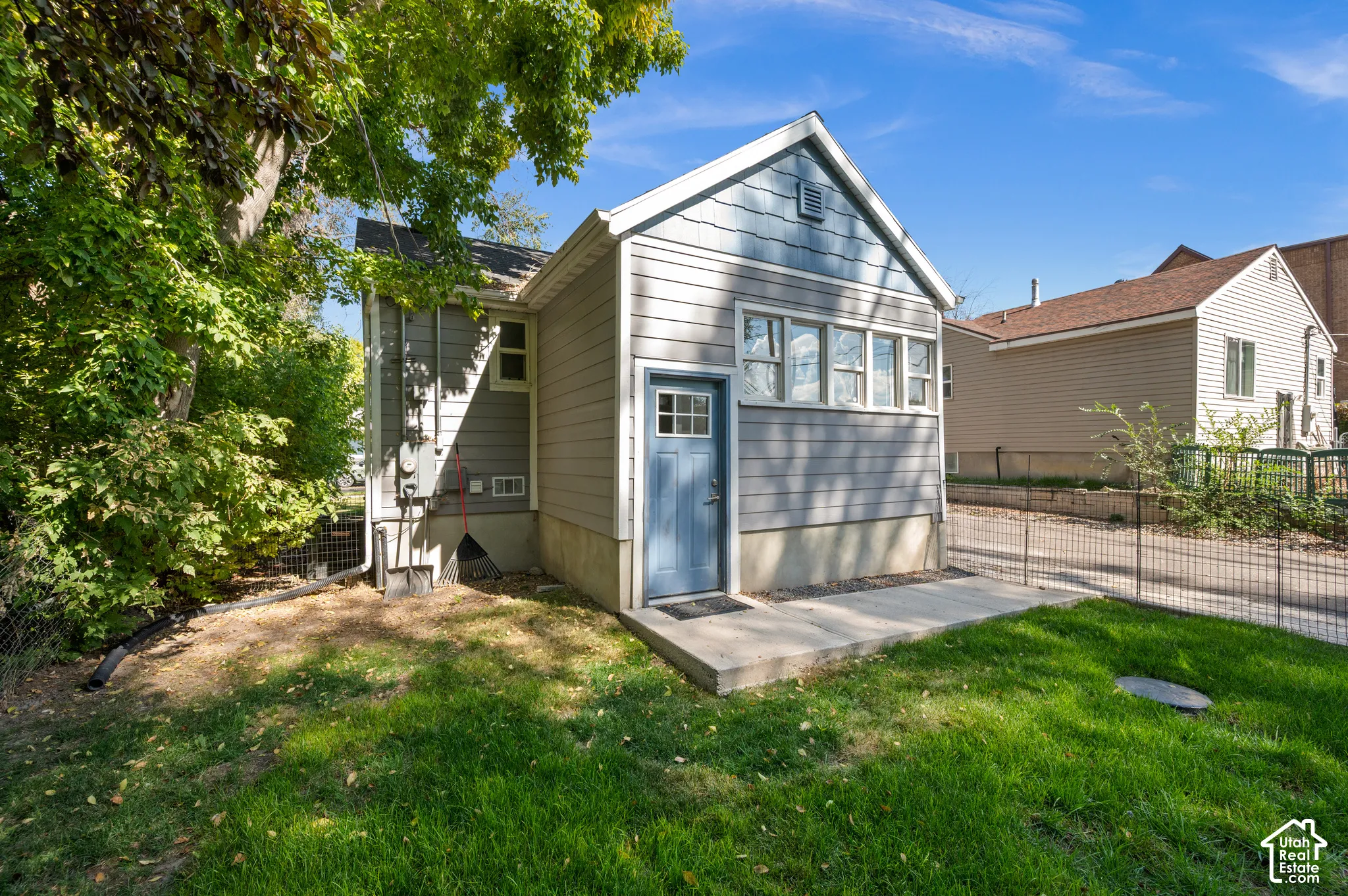 Siding exterior with a gable roofline, multi-pane windows, and a concrete patio