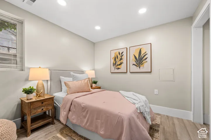 Recessed lighting, wood-finish flooring, and light-toned walls