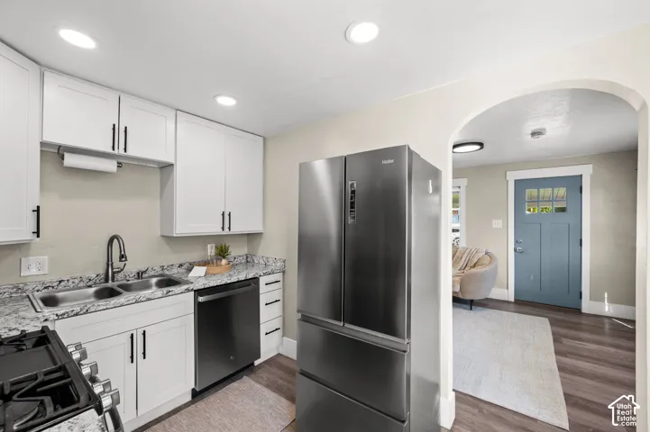 Kitchen with white cabinetry, granite-style countertops, and stainless steel appliances