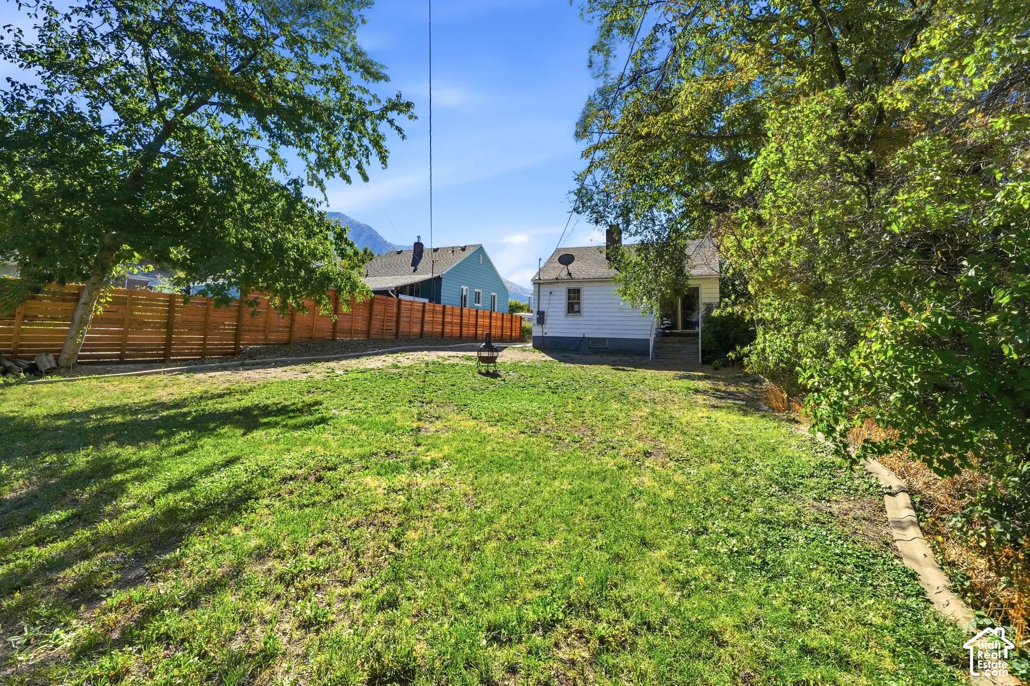 Expansive lawn area with a new horizontal plank fence and mature trees