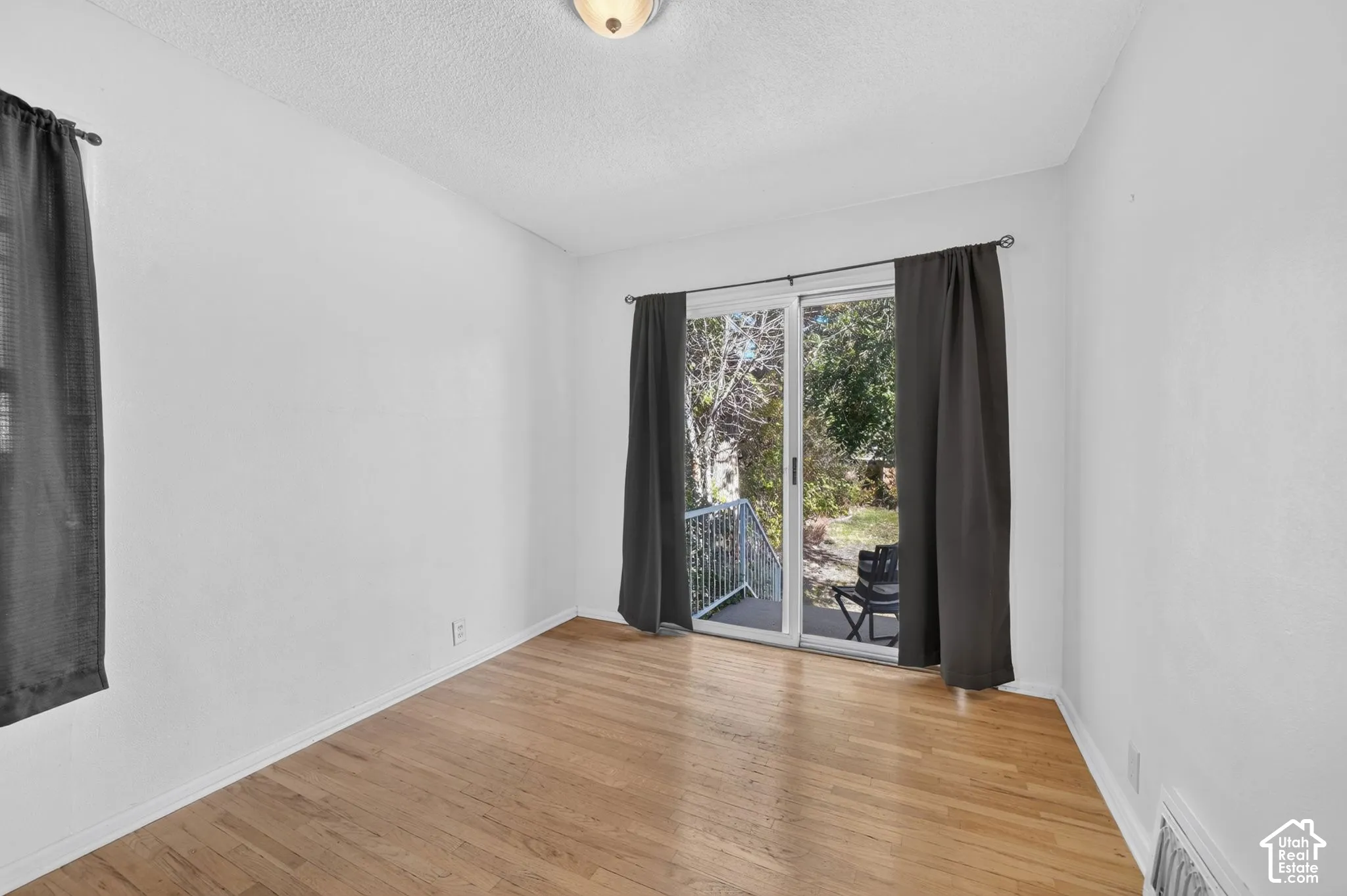 Hardwood flooring, sliding glass door, and white walls