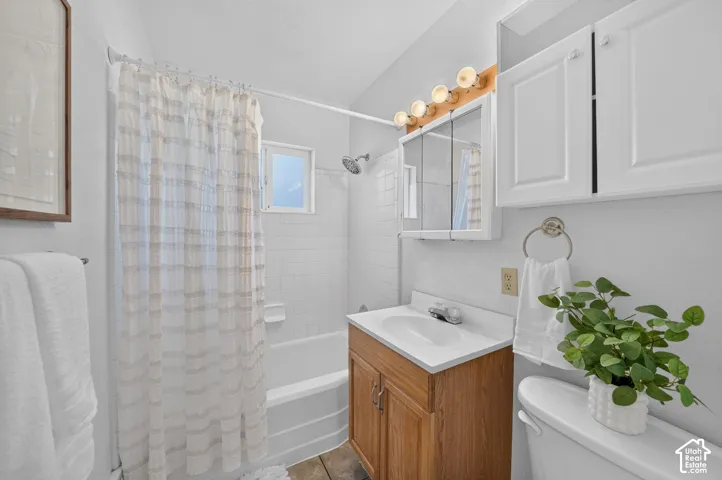 Bright bathroom with a wood-finish vanity, white countertop, and white cabinetry