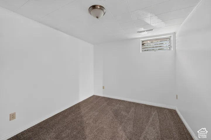 Finished basement room featuring neutral wall finishes, recessed ceiling lighting, and neutral-tone carpeting
