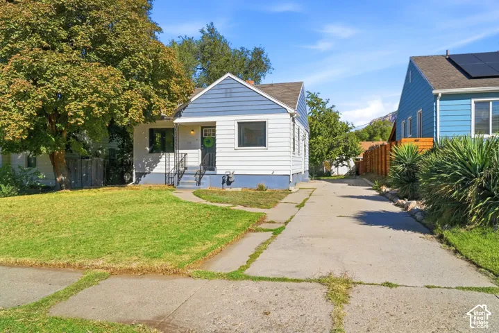 White siding exterior with a blue gable accent and a concrete walkway