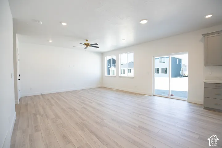 Large family room with 9' ceiling, ceiling fan and sliding glass door.
