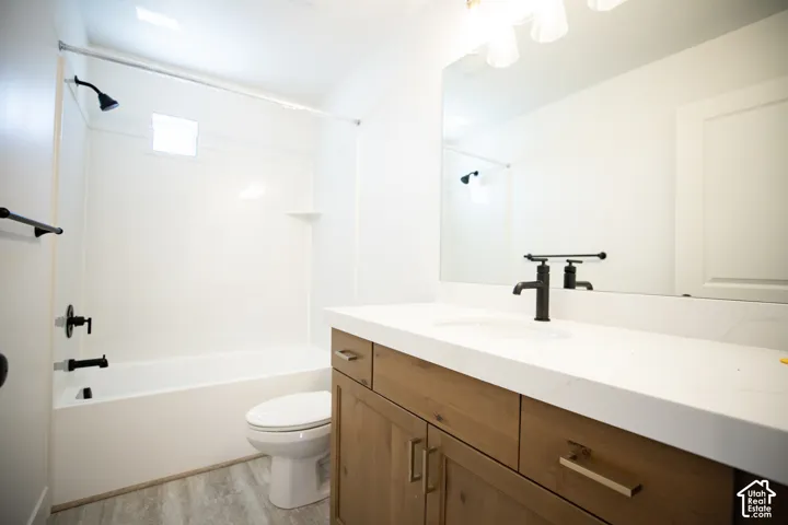 Full secondary bath with stained wood cabinets, extra-long vanity and quartz slab countertop.