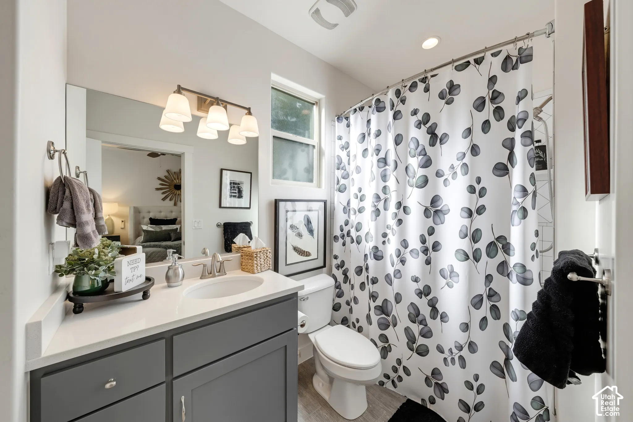 Single vanity with grey cabinetry, white countertop, and integrated sink