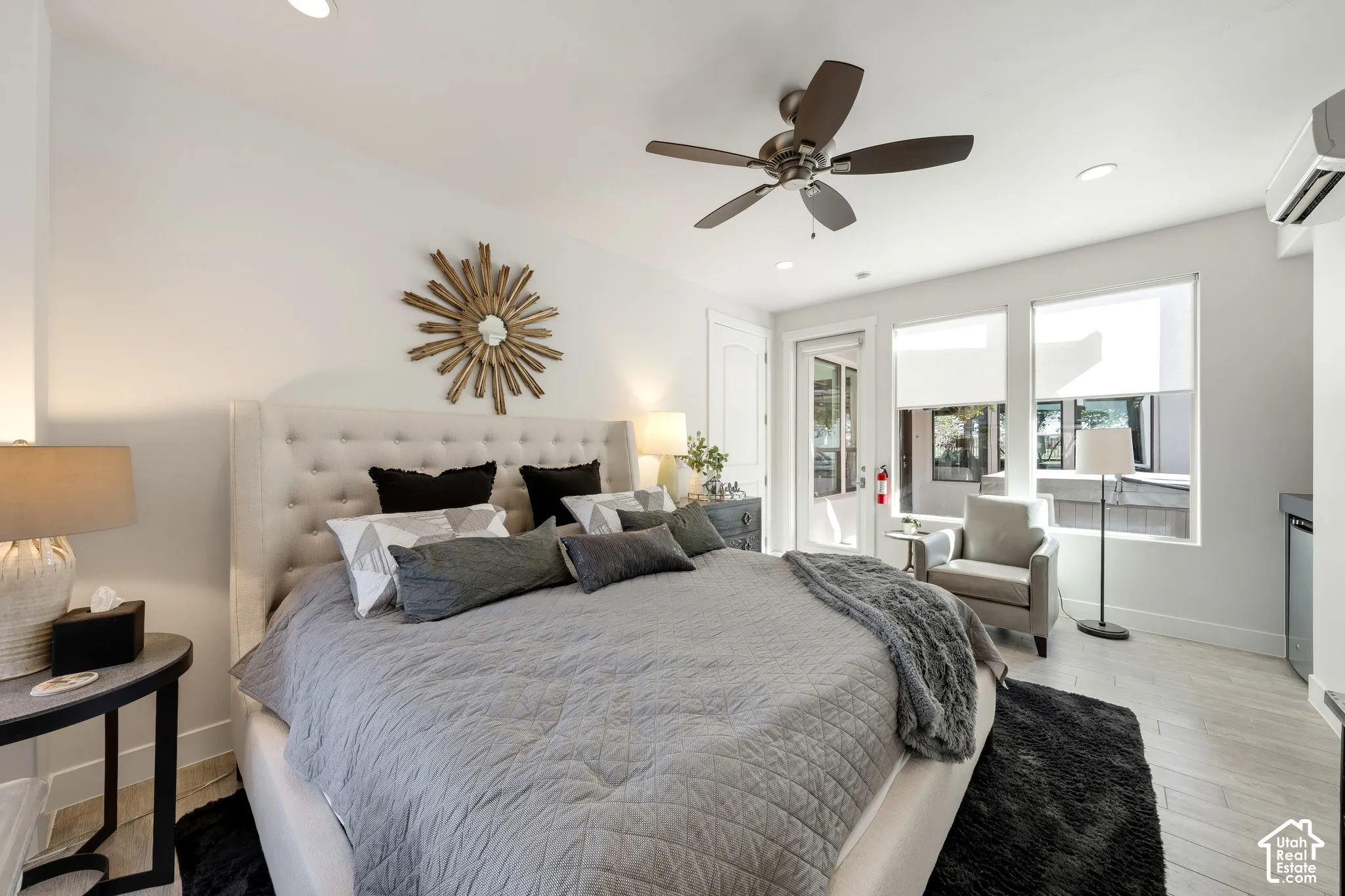 Room featuring a large upholstered headboard, a ceiling fan, recessed lighting, and wood-finish flooring