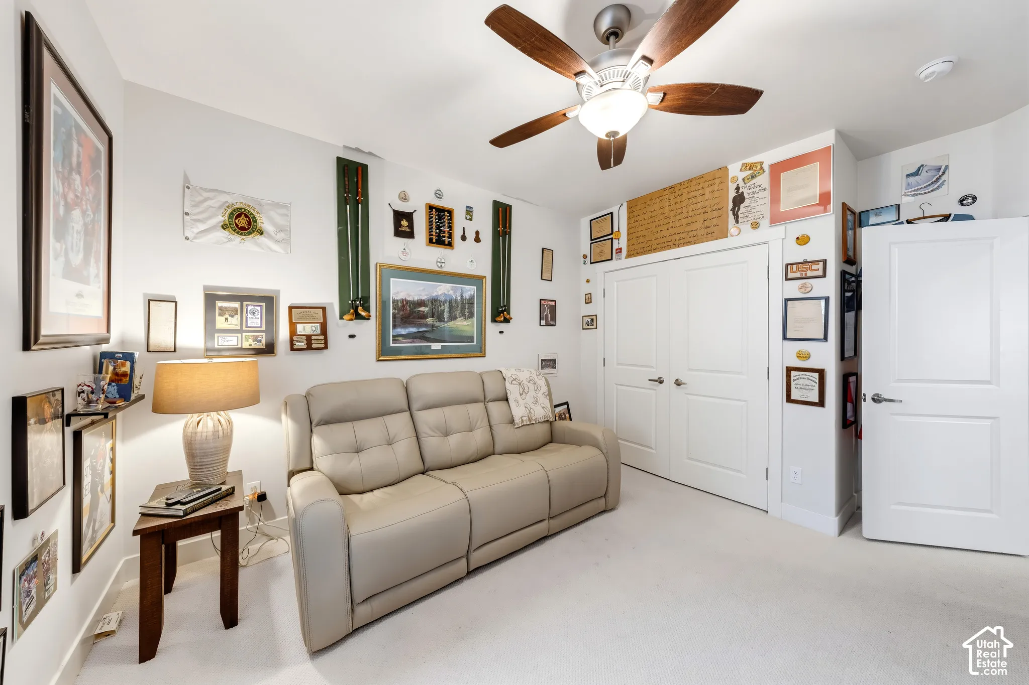 White walls with white trim, a ceiling fan with light fixture, and white bi-fold closet doors