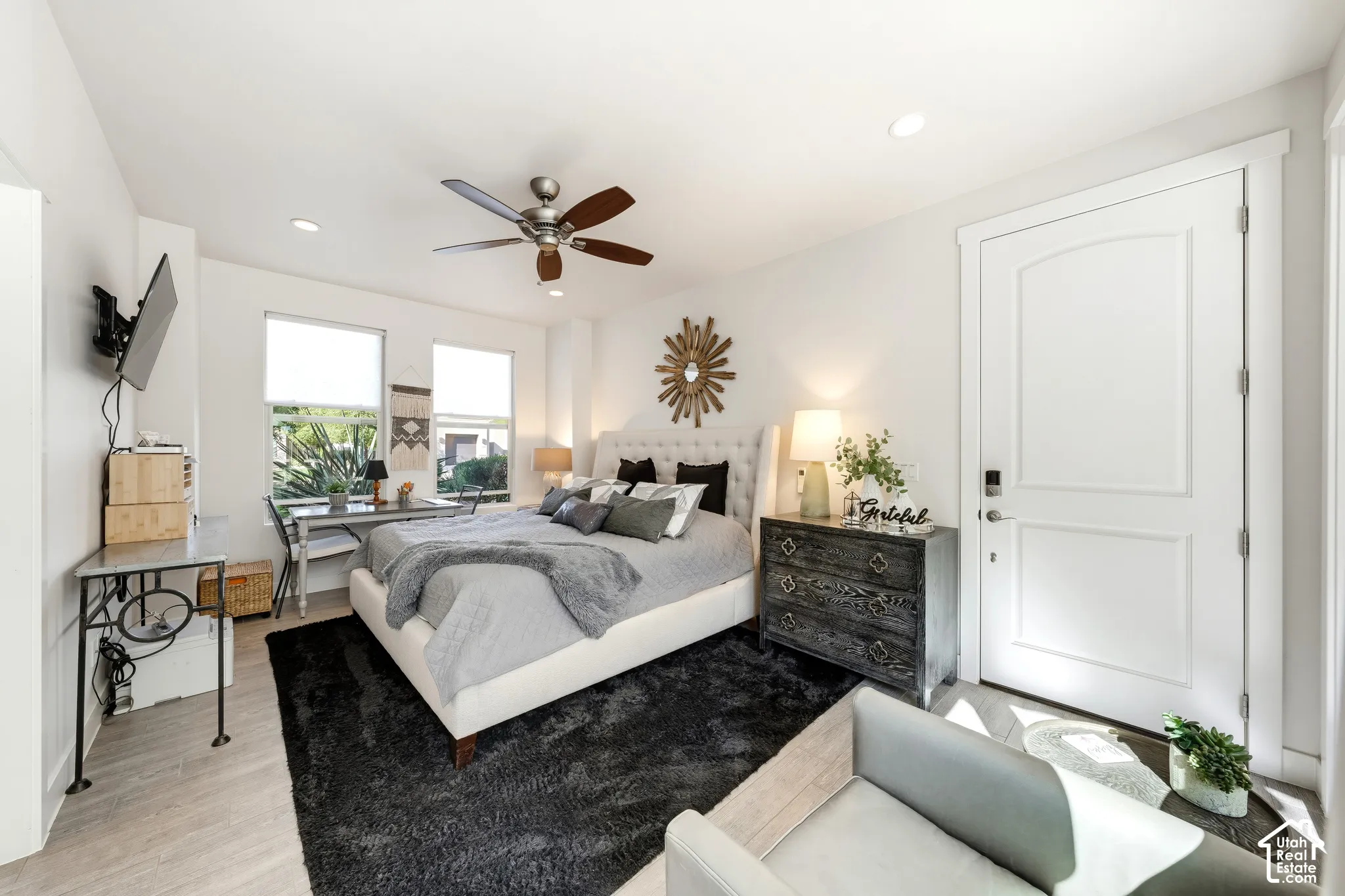 Recessed lighting, ceiling fan, wood-finish flooring, white paneled door, and multiple windows