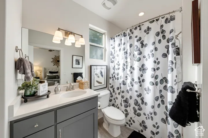 Single vanity with grey cabinetry, white countertop, and integrated sink