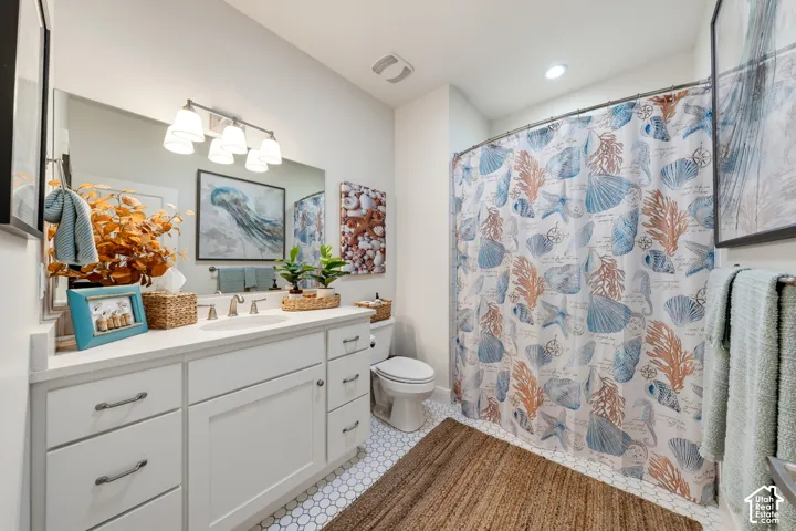White shaker-style cabinetry with brushed nickel hardware, white countertop, undermount sink, and a large vanity mirror with a four-light fixture
