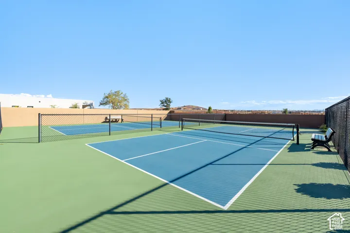 Multiple sport courts with chain-link fencing, featuring a blue and green playing surface with white line markings