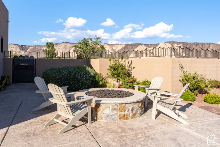 Stone-clad fire pit with a concrete patio