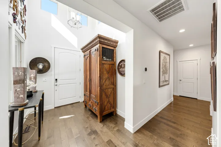 Hardwood-finish flooring throughout, white interior doors, and a high-ceiling entry