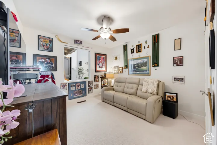 Recessed window opening, neutral tone carpeting, and a ceiling fan with integrated lighting