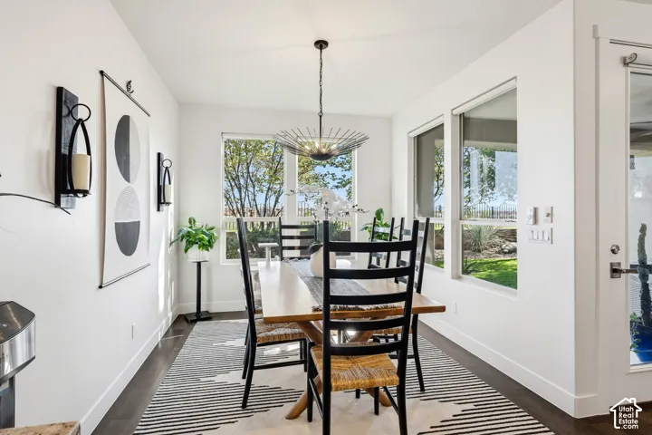 Bright dining area with black ladder-back chairs, wood-finish table, and striped area rug anchoring the space