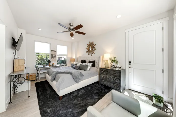 Recessed lighting, ceiling fan, wood-finish flooring, white paneled door, and multiple windows