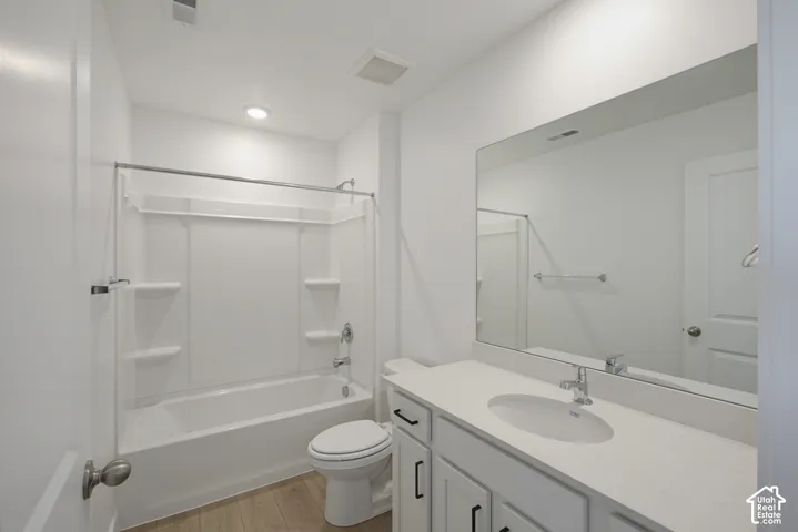 White bathroom vanity with an integrated sink, polished chrome faucet, and rectangular mirror