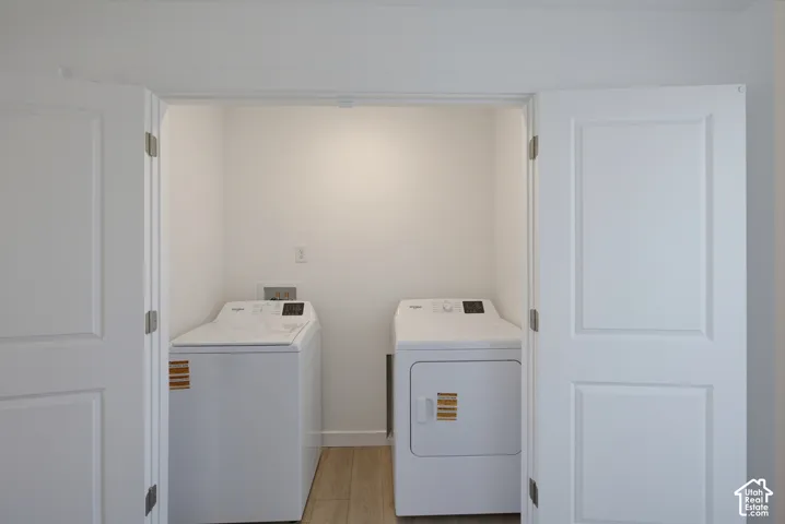 Utility closet with wood-finish flooring and white bi-fold doors
