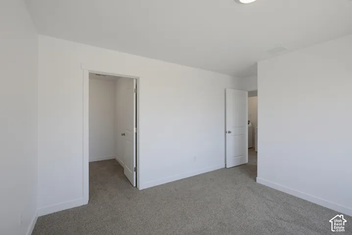 Carpeted flooring, white walls, white trim, and white doors