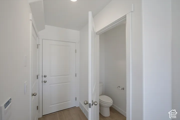 White paneled doors, light wood-finish flooring, and crisp white walls throughout