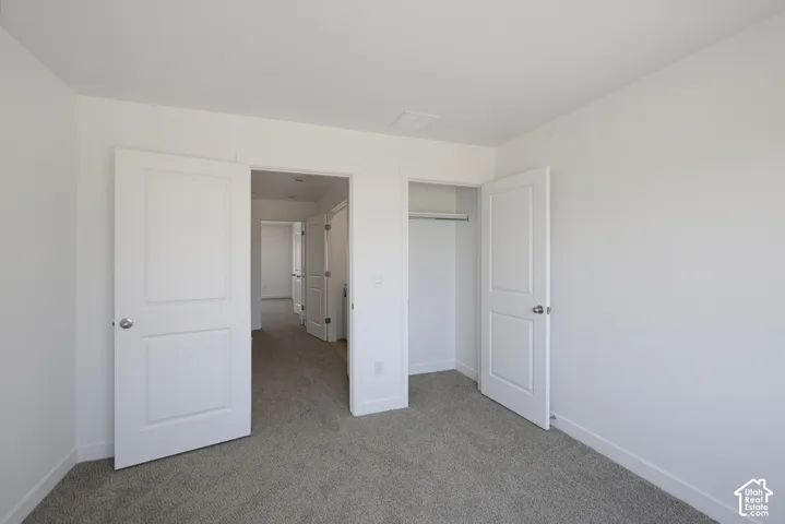 Neutral-toned wall-to-wall carpeting, white interior doors, and a built-in closet rod