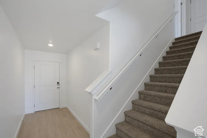 Entryway with wood-finish flooring, recessed lighting, and a white two-panel door