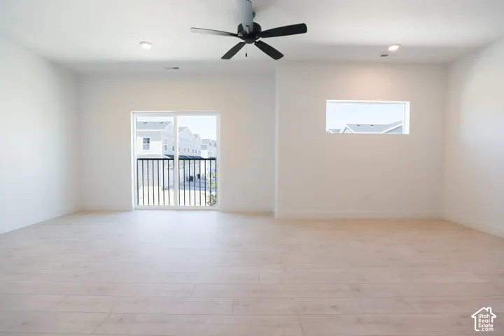 Large family room with ceiling fan and sliding glass door opening to balcony.