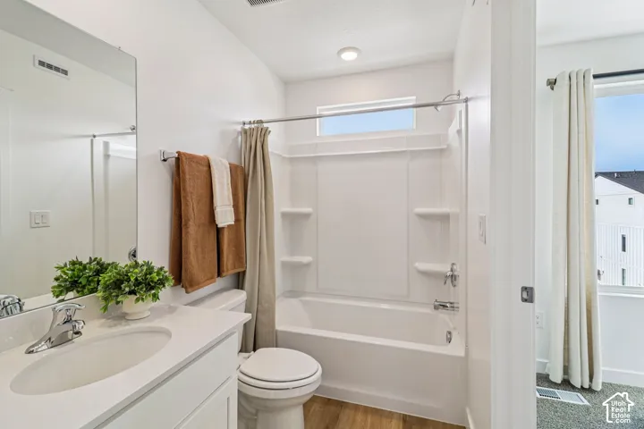 Bathroom with a white vanity, integrated sink, chrome faucet, and full-width mirror