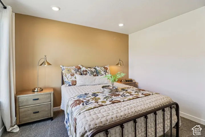 Recessed ceiling lighting, textured wall finish, and wood-finish nightstands with drawer storage