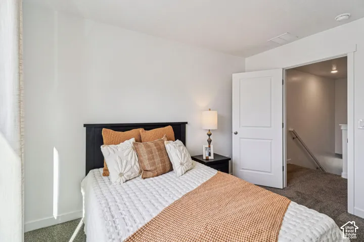Carpeted room with white walls, a single window with blinds, and a two-panel interior door