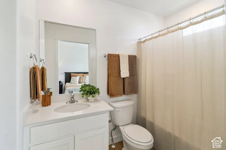 Vanity with a white countertop and integrated sink, chrome faucet, a large wall-mounted mirror, and a shower/tub combination with a white shower curtain rod