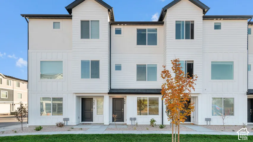 Modern multi-story facade featuring white horizontal siding and vertical board and batten details