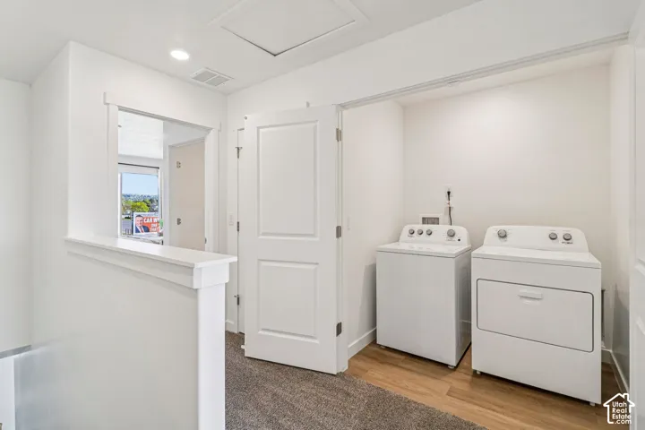 Dedicated laundry area featuring wood-finish flooring