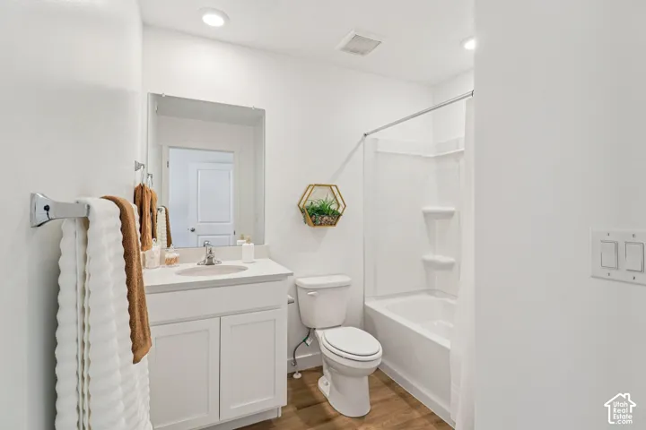 White vanity with integrated sink, chrome faucet, and mirrored wall