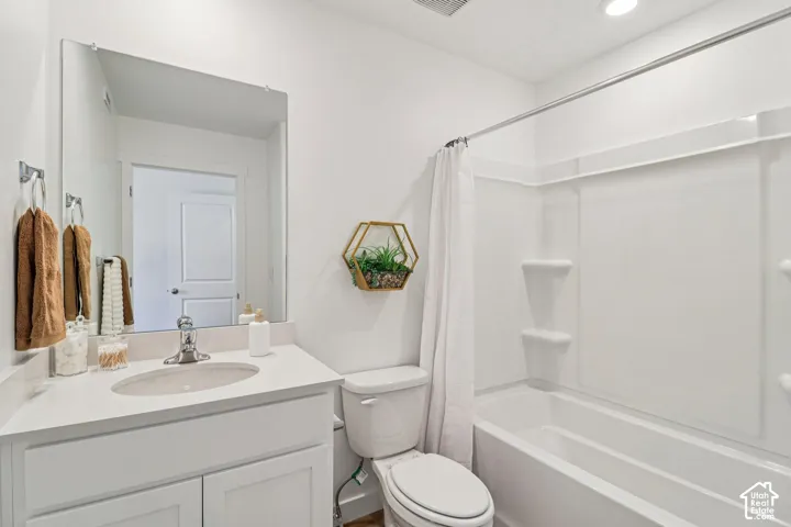 White vanity with a single basin sink, chrome faucet, and expansive wall mirror