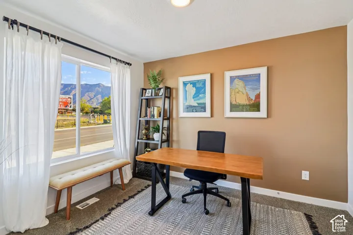 Large window with mountain scenery, neutral tone walls, and built-in shelving