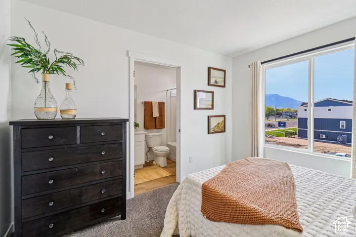 Carpeted flooring, white walls, and a large window with mountain scenery