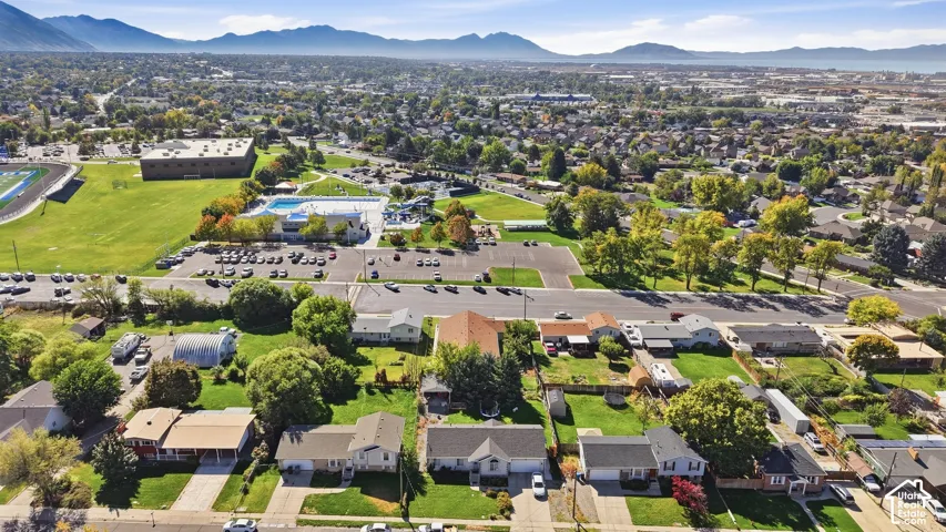 Expansive neighborhood setting with numerous residential properties, mature trees, and mountainous backdrop