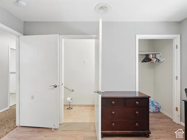 Light wood-finish flooring with a closet featuring a hanging rod