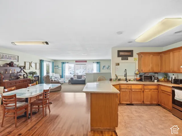 Kitchen with wood-finish cabinetry, light-toned countertops, and tile flooring