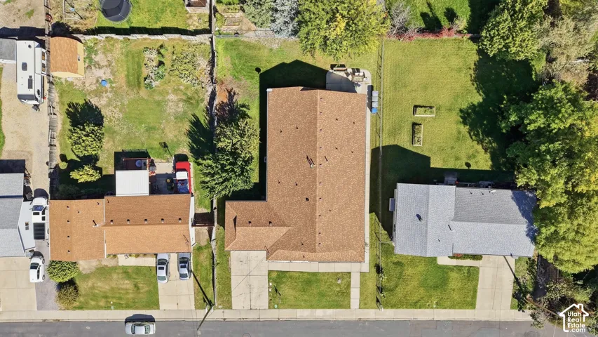 Overhead property view featuring a primary structure with an L-shaped roofline, an additional structure with a rectangular roofline, and a third structure with a rectangular roofline