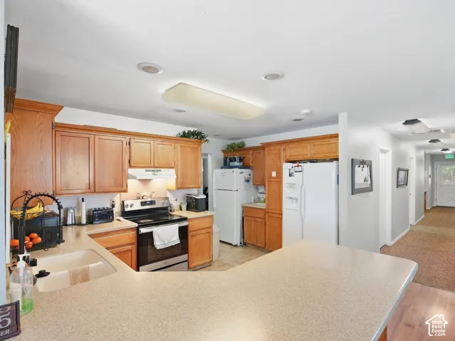 Kitchen featuring wood-finish cabinetry, integrated stainless steel range, and a large countertop