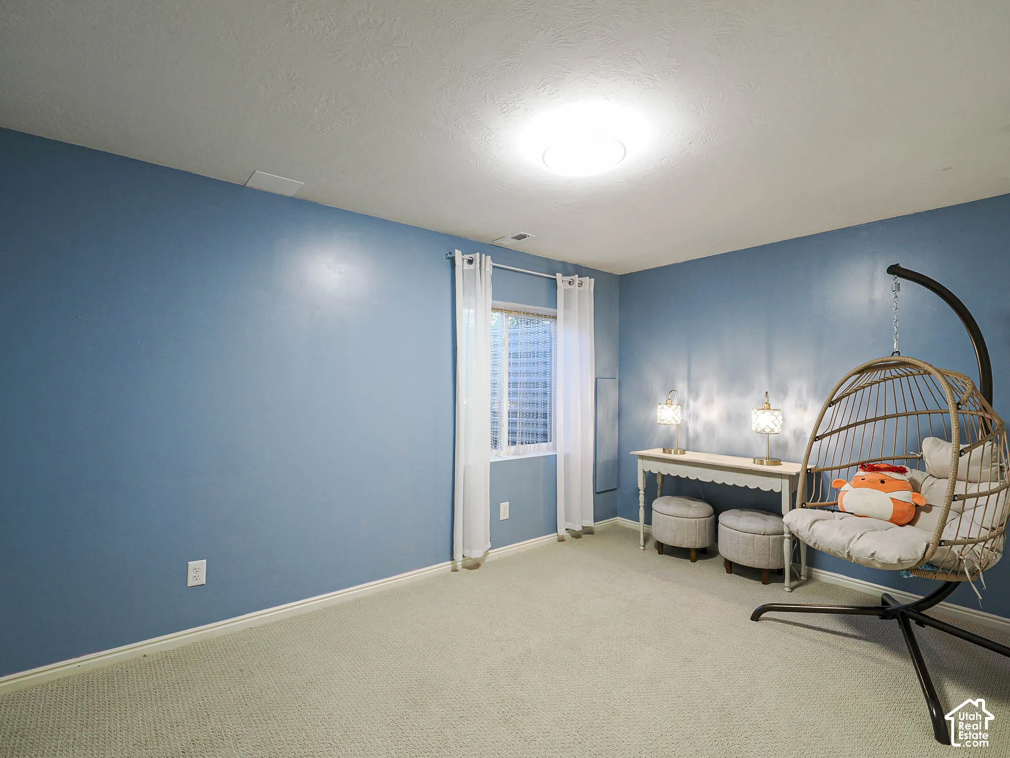 Recessed window, ceiling-mounted light fixture, and light-toned carpet flooring