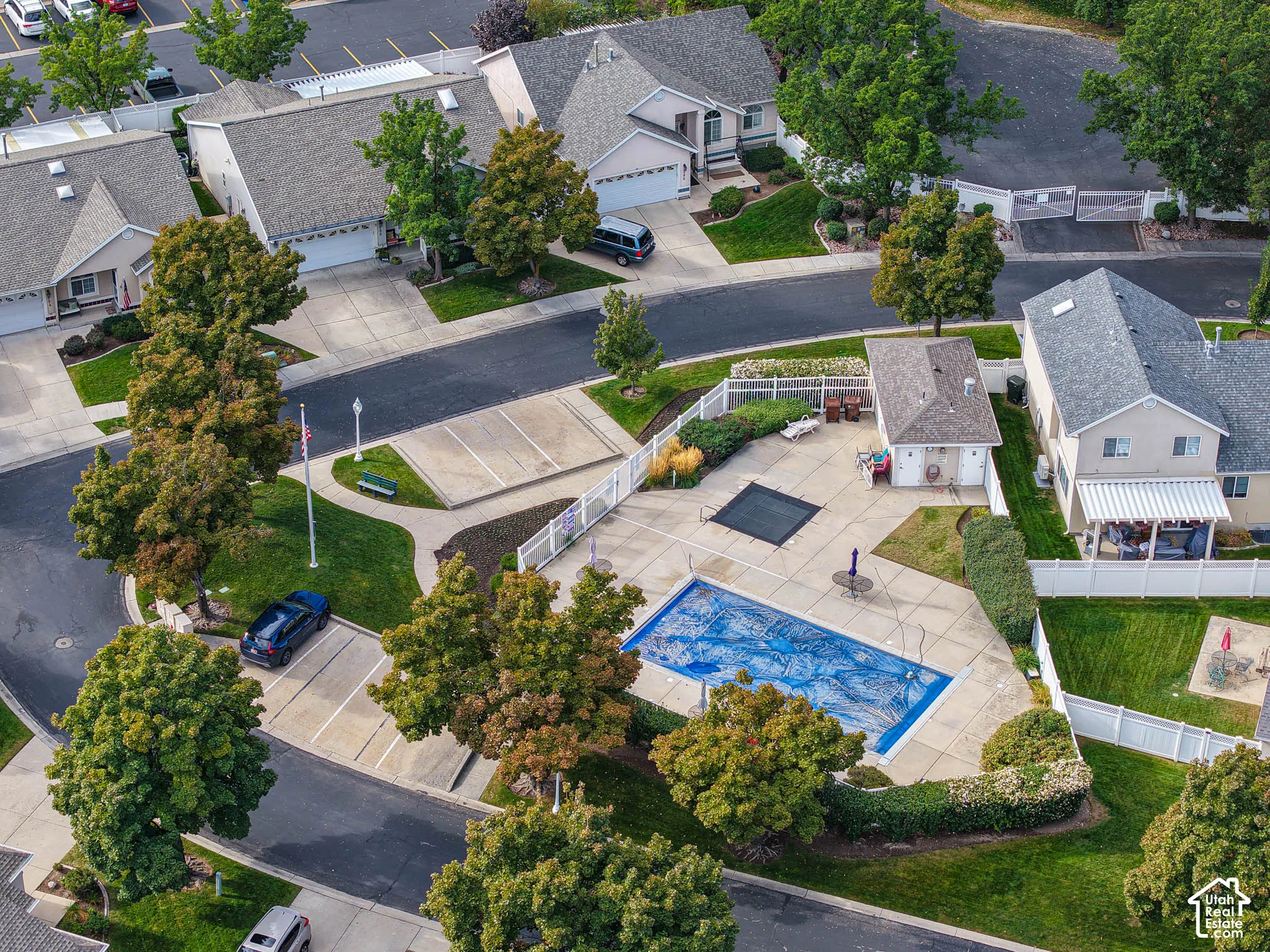 Community pool with concrete decking, surrounding landscaped areas, and an adjacent building