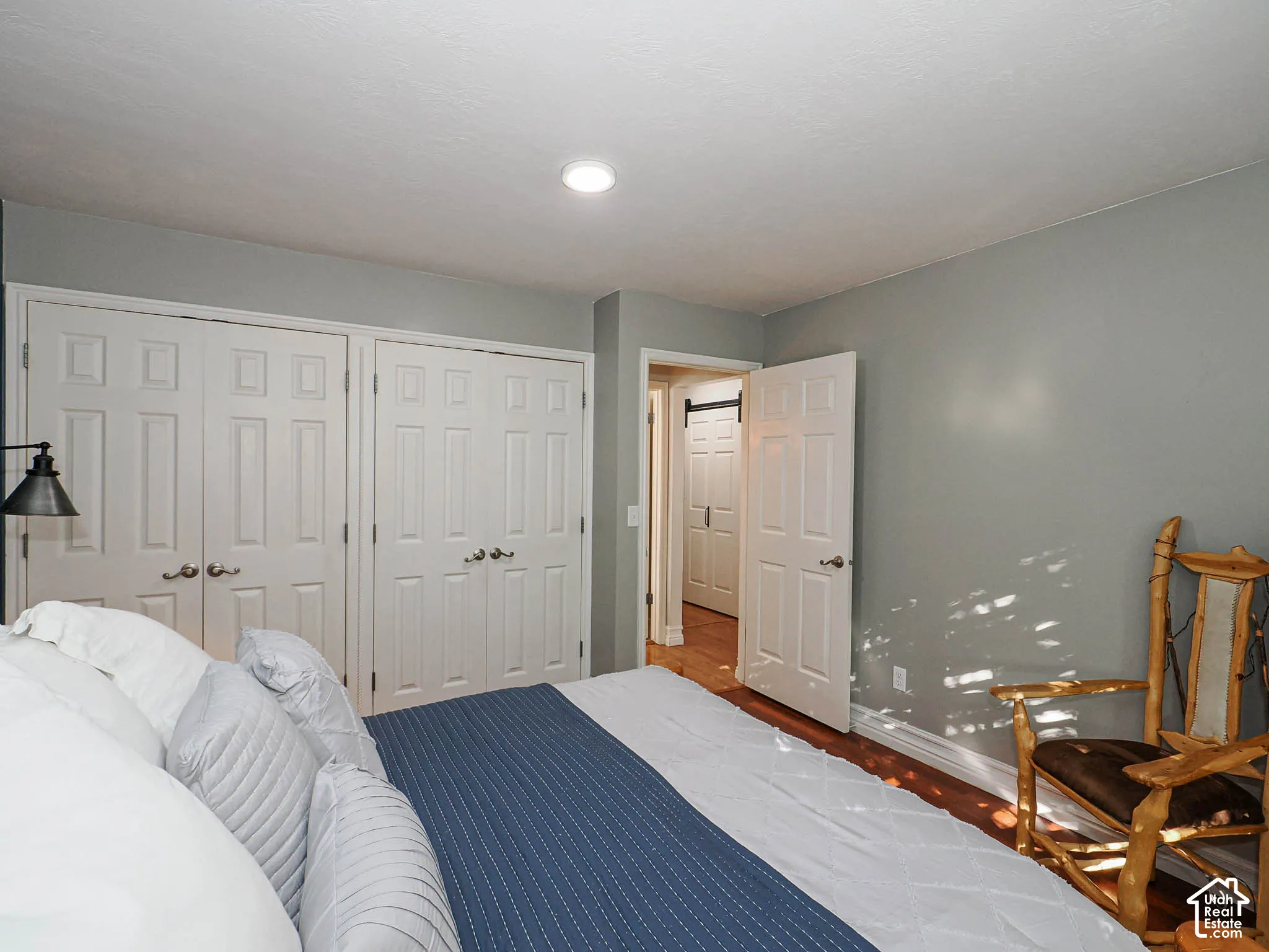 Recessed ceiling lighting, wood-finish flooring, paneled interior doors, and a wall-mounted fixture