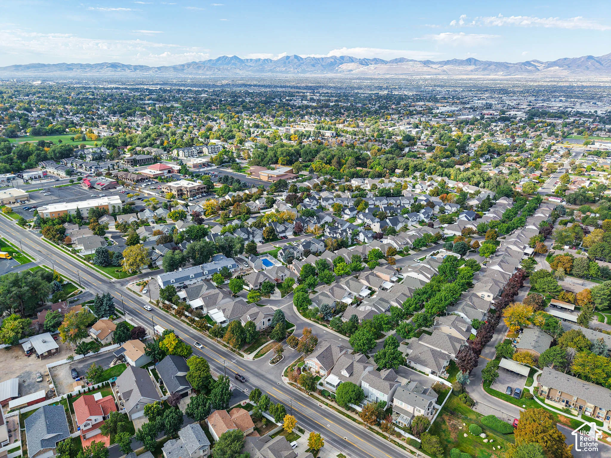 Expansive residential area with a prominent mountain backdrop, featuring a mix of single-family homes and townhomes, and a clear road network