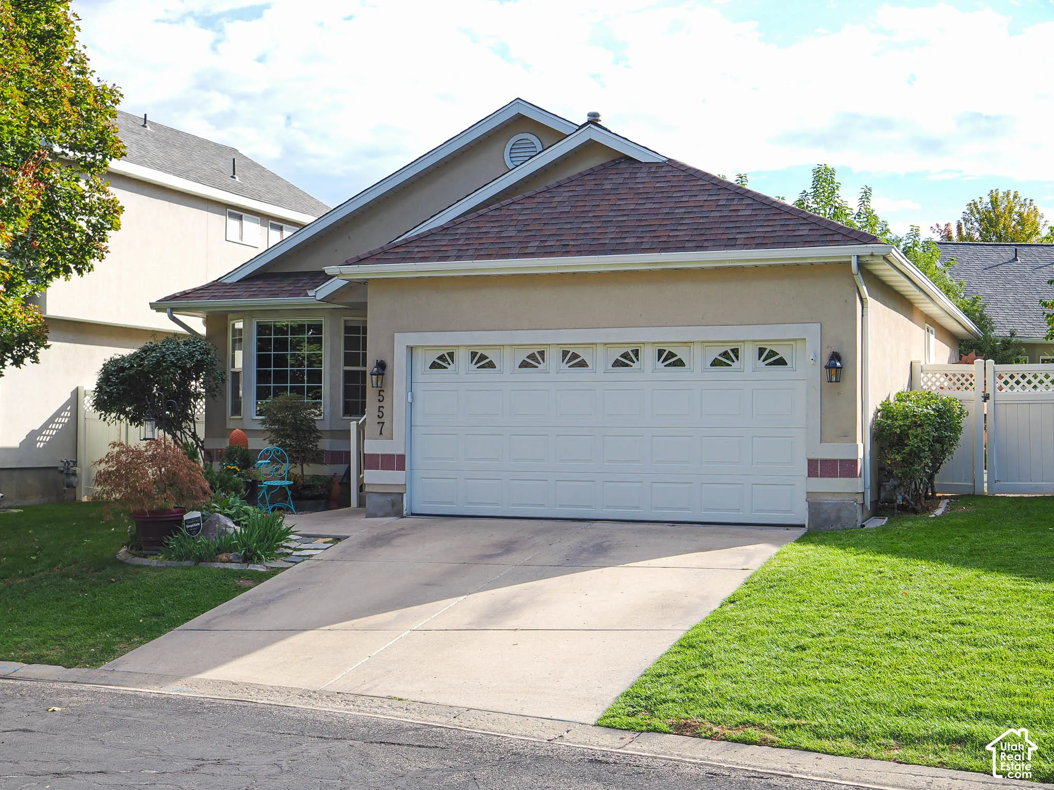 Stucco exterior with a tiled roof, bay window, and an attached two-car garage