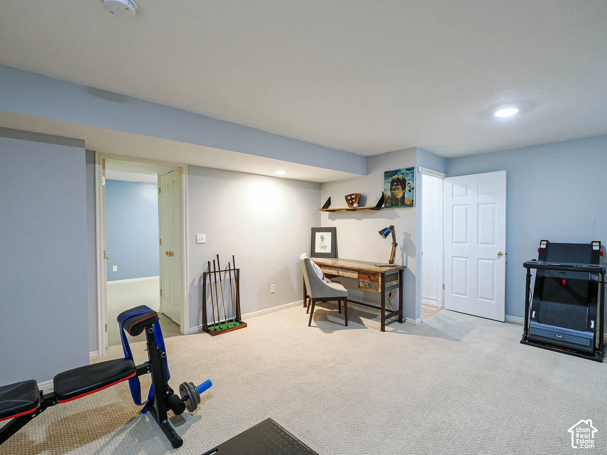 Recessed lighting illuminates the carpeted flooring and light-toned walls